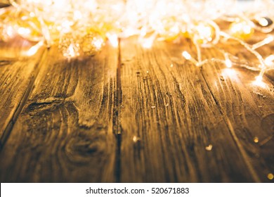 Christmas Fairy Lights On A Wooden Table To Be Used As Background Or Texture.