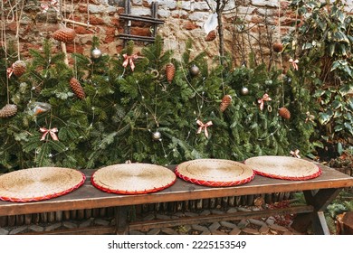 Christmas Family Bench In Garden. Rustic Boho Style Outdoor Decor. Pine Branches, Pine Cones And Straw Decoration. Selective Focus, No Snow