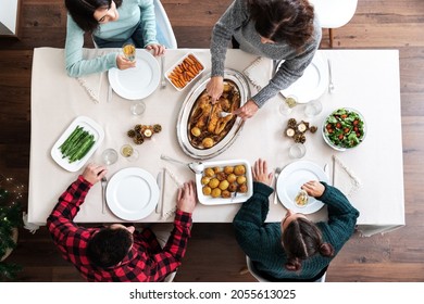 Christmas family dinner top view. Mature caucasian woman carving Christmas roasted chicken. Family gathering. - Powered by Shutterstock