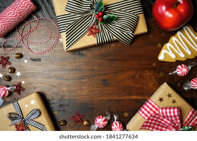 Christmas Farmhouse style red and black Buffalo Plaid check ribbon gifts wrapping concept on a rustic wooden background. Top view blog hero header creative composition flat lay. Negative copy space.