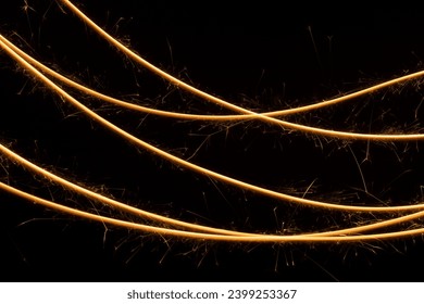 Christmas festive abstract background with burning curved lines of sparkler on black background, pattern. New Year decorative glowing stripe of fire for advertising, design, poster, card, flyer. - Powered by Shutterstock