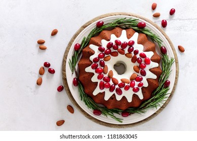 Christmas festive pound cake decorated with cranberries almonds and rosemary twigs, view from above