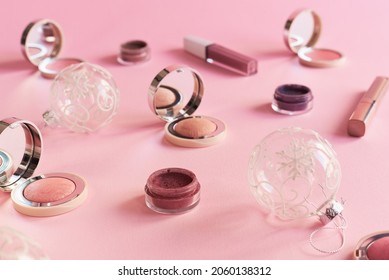 Christmas Festive Season: Beauty Products And Christmas Balls On Pink Background. Blushes, Eyeshadow And Lip Gloss. Christmas Party Makeup