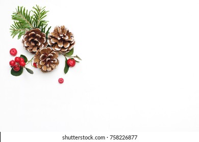 Christmas festive styled stock image floral composition. Pine cones, fir tree branches and red gaultheria berries on white wooden background. Flat lay, top view with empty copy space. - Powered by Shutterstock