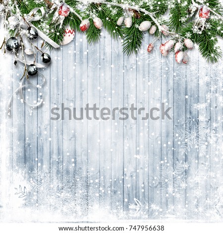 Christmas firtree with holly, snowfall on wooden white board