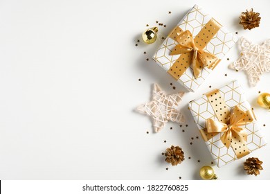 Christmas Flat Lay Composition. Christmas Golden Decorations, Gift Boxes, Stars, Confetti On White Background. Christmas, New Year, Winter Holiday Celebration Concept. Greeting Card, Postcard Mockup