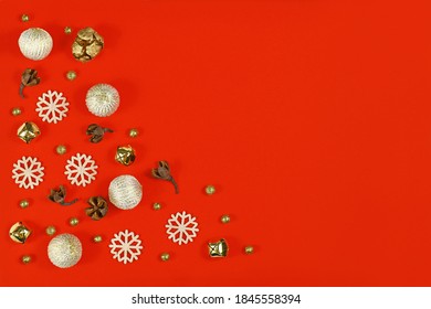 Christmas Flat Lay With Wooden Snowflake Ornaments, Golden Bells And Balls And Tree Ornament Baubles On Bright Red Background With Empty Copy Space