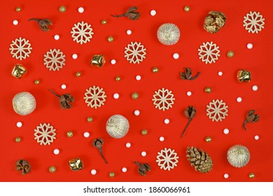 Christmas Flat Lay With Wooden Snowflake Ornaments, Golden Bells And Balls And Tree Ornament Baubles Arranged On Bright Red Background 