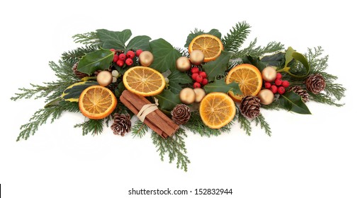 Christmas Floral Arrangement With Gold Bauble Decorations, Dried Orange Fruit, Spice With Holly And Winter Greenery Over White Background.