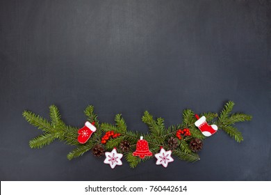 Christmas floral decoration with toys, holly berry, pine cones and winter greenery over chalkboard. Copy space for you text - Shutterstock ID 760442614