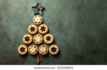 Christmas food Background with fir tree made from traditional british christmas Mince pies, anise stars and cinnamon stickes on a green table surface.  Pastry also called mincemeat or fruit pie. - Powered by Shutterstock