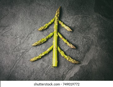 Christmas Food Background. Christmas Tree Made From Fresh Asparagus On Black Stone Slate Background. Healthy Holiday Food, Vegan, Vegetarian And Diet Concept. Toned