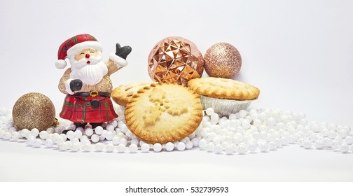 Christmas Food And Decoration With Santa, Ornament And And Mince Pies On White Background For Festival Of Christmas And New Year. Holidays Season.