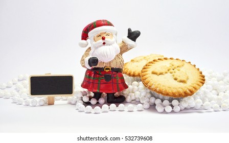 Christmas Food And Decoration With Santa, Sign, And Mince Pies On White Background For Festival Of Christmas And New Year. Holidays Season.