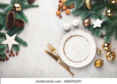 Christmas frame background with empty plate, golden cutlery and decorated fir tree. Top view, copy space for text or design, graphics - Powered by Shutterstock