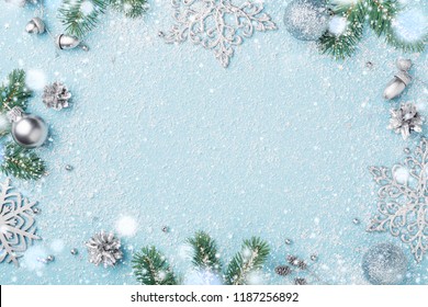 Christmas Frame. Decorations, Fir, Silver New Year Ornaments. Holiday Snowy Background, Light Blue Copy Space.