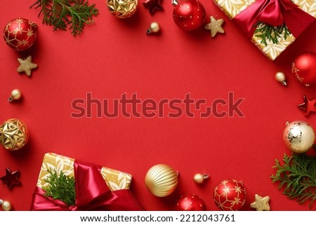 Christmas frame. Gift boxes with Xmas tree branches, golden stars and baubles on red background. Flat lay, top view, copy space. Christmas banner mockup, festive website header template