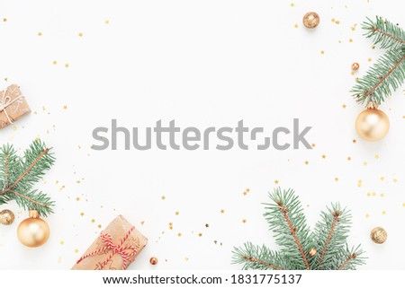 Christmas frame of green branches, gifts, gold Christmas decorations on white background. Copy space, flat lay.