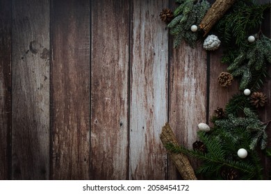 Christmas frame with various christmas accessories like chain, nuts, balls, pine cones on a brown wooden background, rustic photography as a background or decoration, vintage style