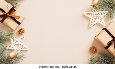 Christmas Frame. Xmas Tree Branches Decorated Gift Boxes, Stars And Balls On Beige Background. Flat Lay, Top View, Copy Space. Christmas Banner Mockup, Poster Template.