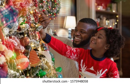Christmas Fun With Daddy. Little Black Girl Helping Father To Decorate Family Xmas Tree, Enjoying Winter Holidays Together, Panorama