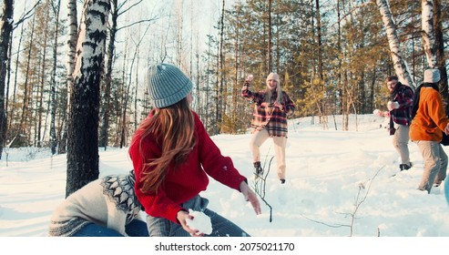 CHRISTMAS FUN. Happy Group Of Diverse Friends Play Snowball Fight At Amazing Snowy Winter Forest With Dog Slow Motion.