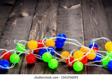 Christmas garland with colorful balls on a wooden floor close-up - Powered by Shutterstock