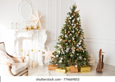 Christmas Gift Box In Light Coloured Interior Room Decorated In Christmas Style. No People. An Empty Chair. Neutral Colors. Home Comfort Of Modern Home.