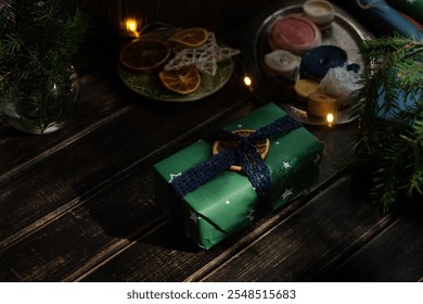 Christmas gift box wrapped in green paper decorated lace ribbon and dried orange. Christmas present on wooden table. - Powered by Shutterstock