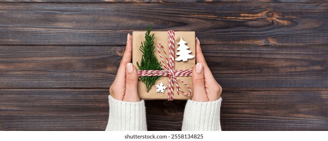 Christmas gift box wrapped in recycled paper, with ribbon bow, with ribbon on rustic background. Holiday concept. - Powered by Shutterstock