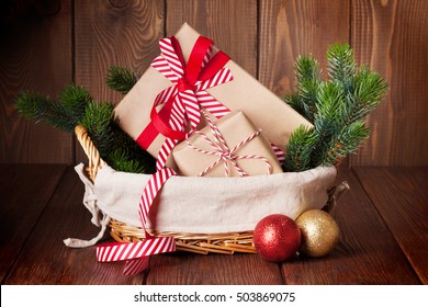 Christmas Gift Boxes And Fir Tree Branch In Basket On Wooden Table