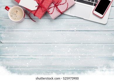 Christmas Gift Boxes, Laptop, Smartphone And Coffee Cup On Wooden Background. Top View With Copy Space For Your Text