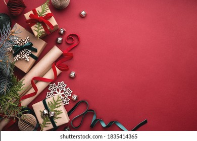 Christmas Gift Boxes, Velvet Ribbons, Rolls Of Wrapping Paper And Decorations On Red Background.