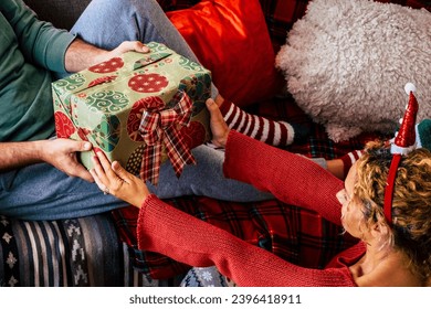 Christmas gift concept with happy woman giving present to his husband at home. Holiday new year season. Couple enjoying celebration alone with love. People and xmas time celebration relax. December - Shutterstock ID 2396418911