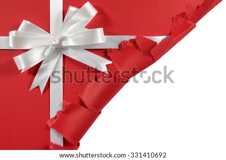 Christmas gift corner torn open, white ribbon bow, red paper background, copy space