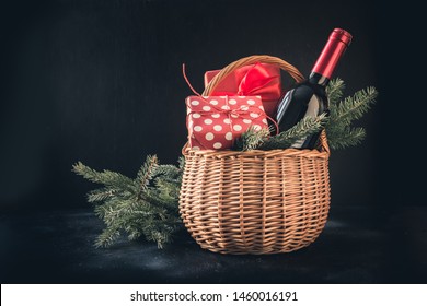 Christmas gift hamper with red wine and gift on black. Space for your greetings. Xmas. - Shutterstock ID 1460016191