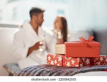 Christmas gift, present and happy couple celebrate the holiday at hotel with champagne. Love, happiness and vacation celebration of a girlfriend and boyfriend smile and drink in a bedroom together - Powered by Shutterstock