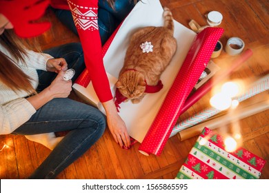 Christmas gift wrapping background with a new year decor, old paper and gifts and cat lies on a wooden background - Powered by Shutterstock