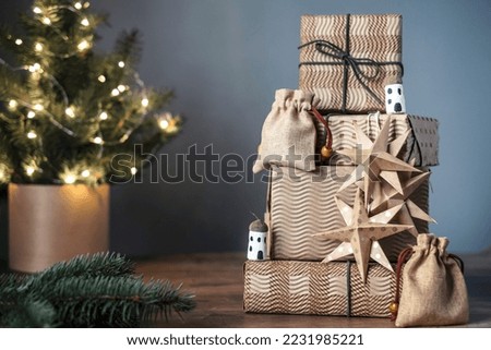 Christmas gifts, little cotton bag, stars, acorn huts on wooden background near the Christmas tree. DIY organic sustainable Christmas decoration. Zero waste and plastic free concept. 