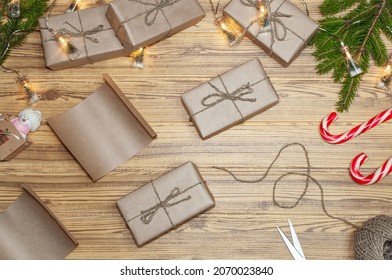 Christmas Gifts Wrapped In Kraft Paper And Tied With Linen Twine. Preparing For The Holiday And Wrapping Gifts. Mess On The Table In Preparation For The Holiday. Christmas Eve 2022