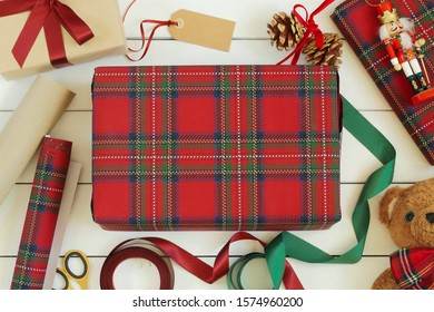 Christmas gifts wrapping, preparation for holiday, xmas concept. Wrapped presents, ribbons, paper rolls and toys on white wooden table. Top view. - Powered by Shutterstock