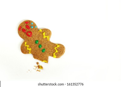 A Christmas Gingerbread Cookie Man Is Upset Because Someone Has Eaten His Leg, And Crumbs Are Left Behind On An Isolated White Background