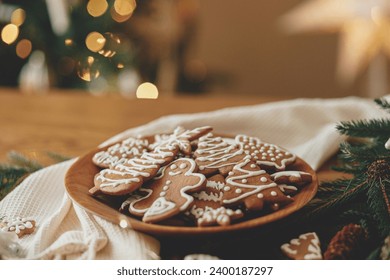 Christmas gingerbread cookies with icing in plate on festive rustic  table with decorations against golden illumination. Merry Christmas! Delicious gingerbread cookies, atmospheric holiday eve - Powered by Shutterstock