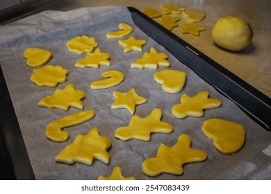 Christmas gingerbread cookies on a baking tray beside unprepared cookie dough, capturing the festive baking process and holiday preparation. - Powered by Shutterstock