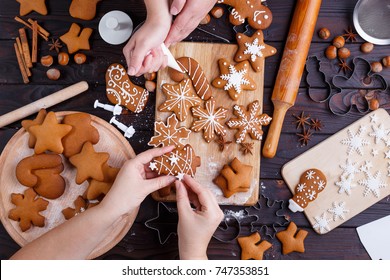 Christmas gingerbread making. Friends decorating freshly baked cookies with icing and confectionery mastic, view from above. Festive food, family culinary, Christmas and New Year traditions concept