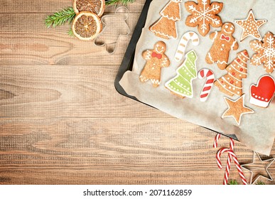 christmas gingerbread on a baking sheet and christmas decorations on a wooden table - Powered by Shutterstock