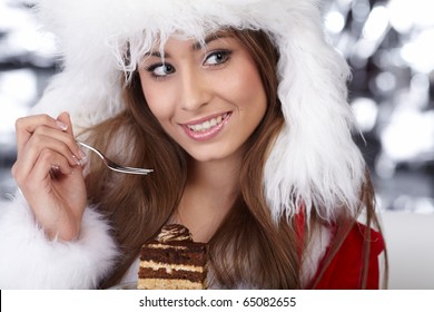 Christmas Girl In Red Santa Hat Eating Cake On Plate