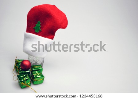Christmas glass with red hat , copy space. Minimal flat lay Christmas theme. New year party concept.