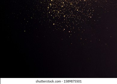 Christmas Gold Glitter On Black Background. Holiday Abstract Texture. Golden Explosion Of Confetti.