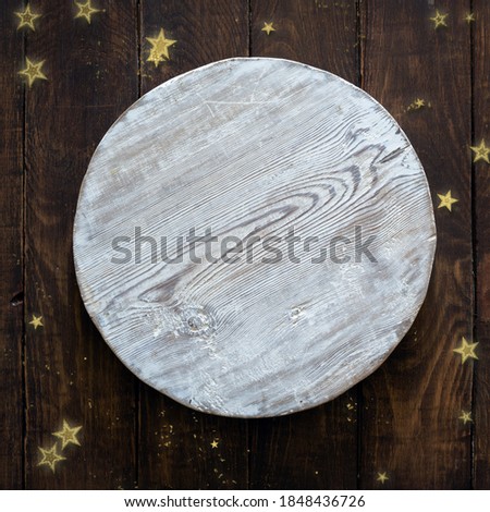 Christmas golden confetti on wooden background with white circle